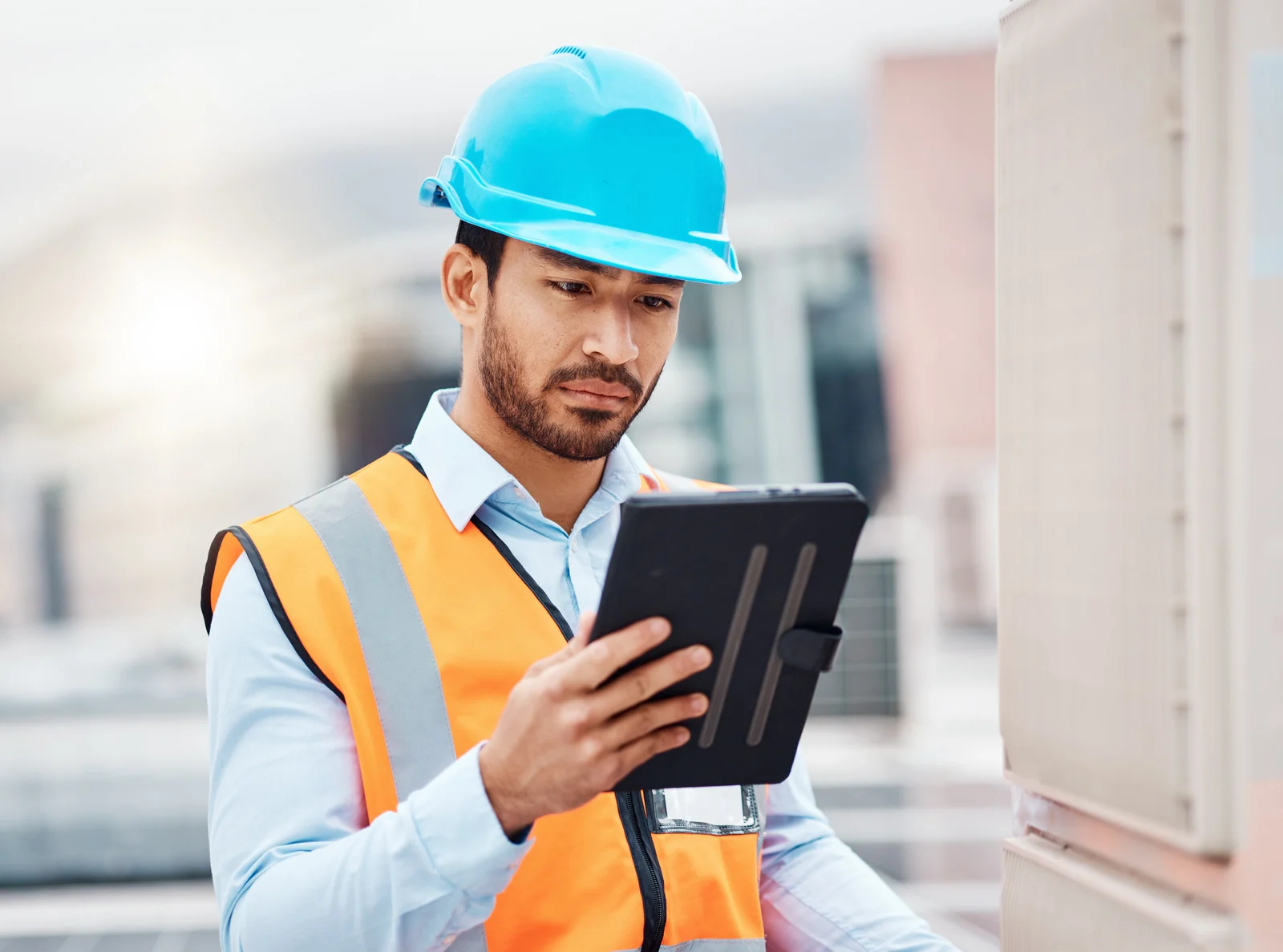 Contractor on a job site using a tablet to look up licensing requirements